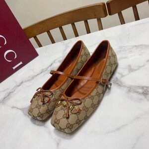 Gucci Women's Brown Monogram Flats with Bow and Gold Detail